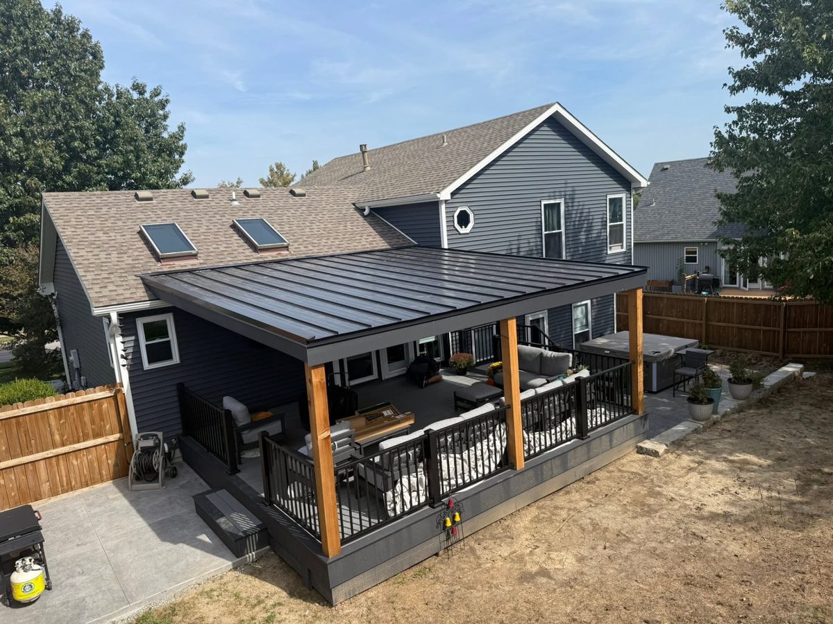 Two-tone deck beneath a custom black metal-roofed outdoor living area
